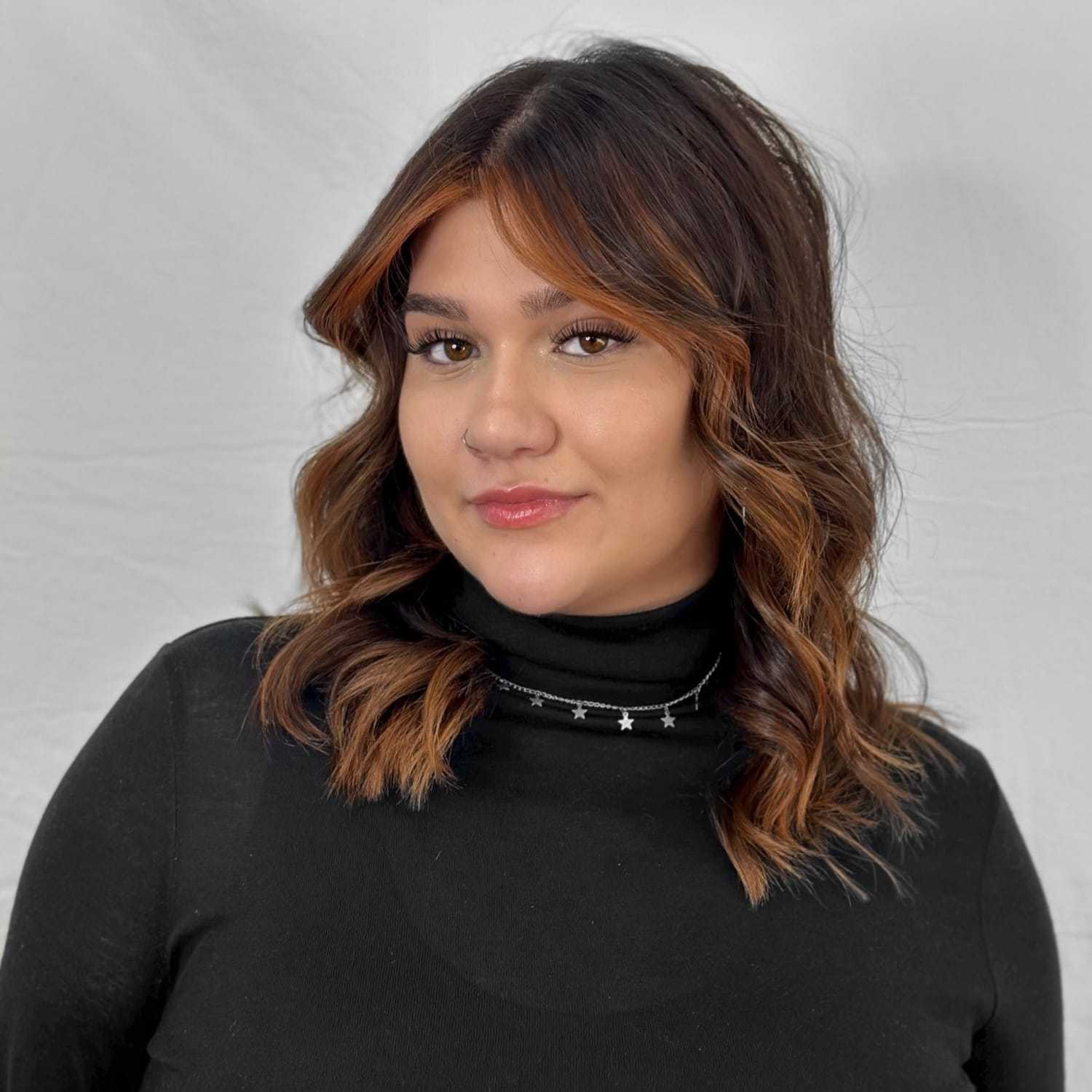 Portrait of Julia, a professional stylist at ARIA Salon, showcasing their expertise and style.