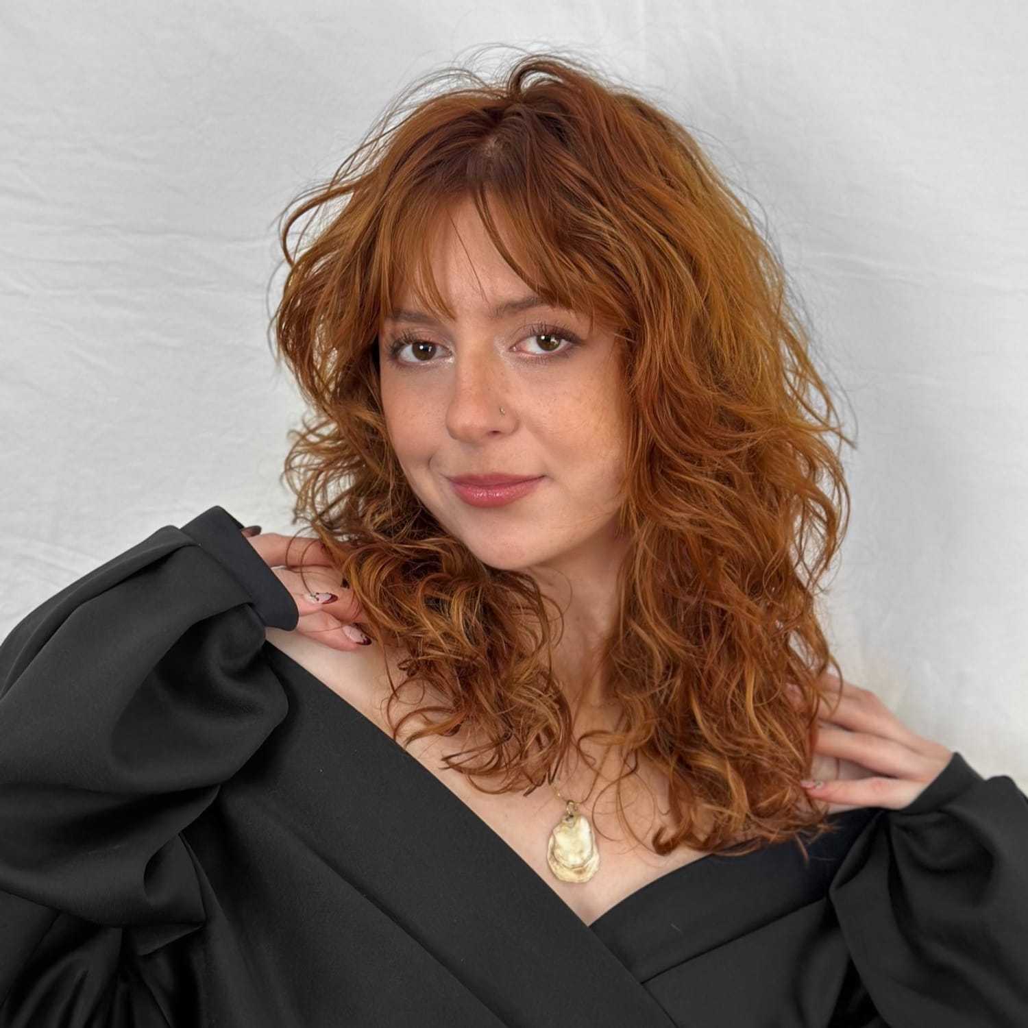 Portrait of Marcia, a professional stylist at ARIA Salon, showcasing their expertise and style.